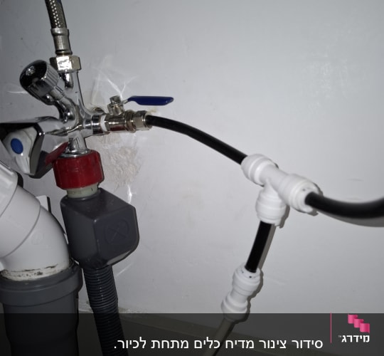 צינורות חיבור עם ברזים מתכתיים מתחת לכיור